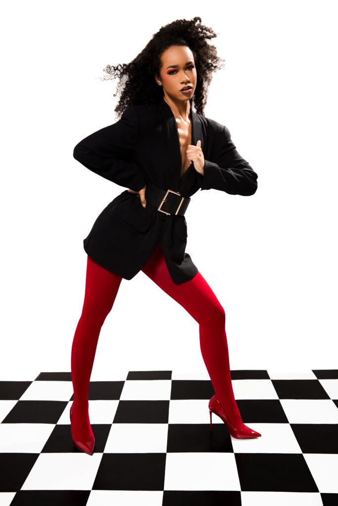 Model posing on top of a checkerboard floor for a fashion photography photoshoot.